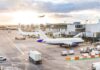 Airport with airplanes, runway, and terminal at sunset.