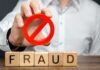 Blocks spelling fraud with hand holding red prohibition sign