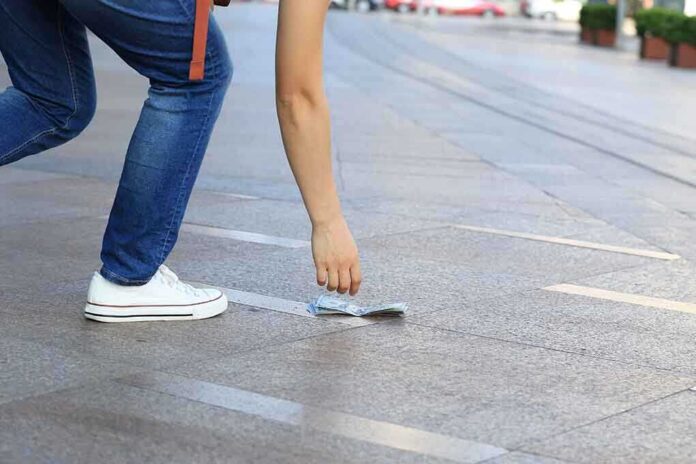 485328910 featured image Person picking up money from the ground.