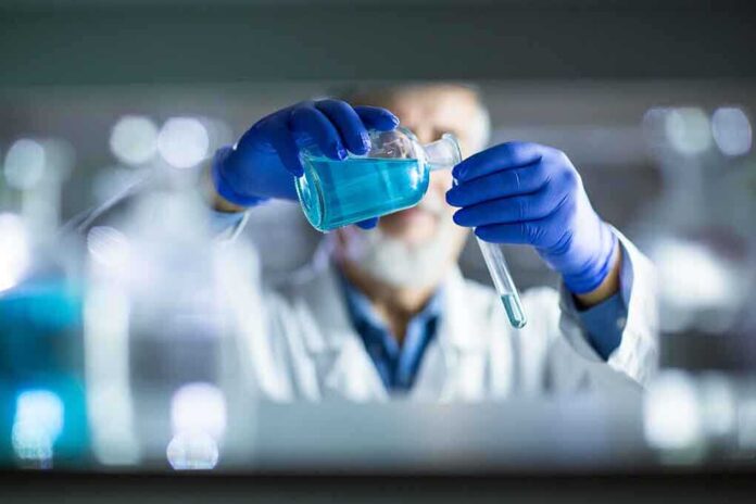 517925923 featured image Scientist pouring blue liquid into test tube.