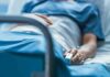 Person lying in hospital bed with monitor attached