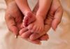 Adult hands holding baby feet gently