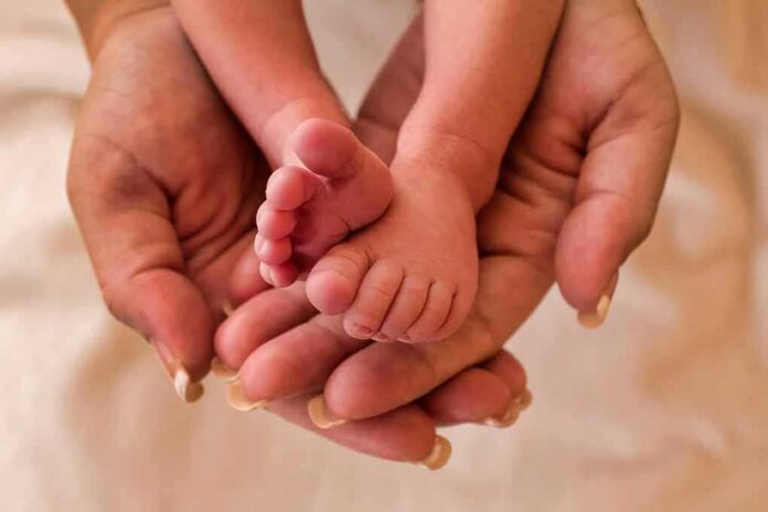 1247118406 featured image Adult hands holding baby feet gently
