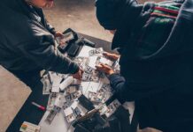 Two individuals handling stacks of money on a table