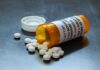Pills spilled from orange prescription medicine bottle