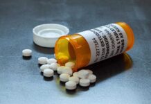 Pills spilled from orange prescription medicine bottle