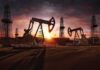 Oil rigs operating at sunset in a desert landscape