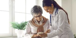 Doctor showing phone to a smiling elderly woman