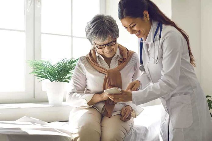 Doctor showing phone to a smiling elderly woman