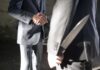 Two men shaking hands one holding hidden knife