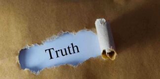 Ripped paper reveals word truth underneath brown surface