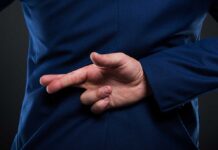 Person crossing fingers behind their back in suit