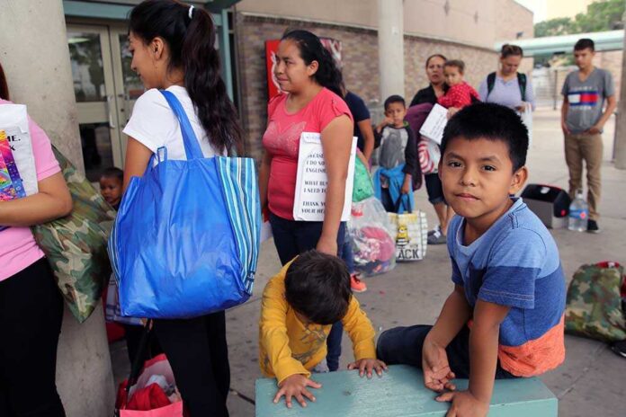People waiting outside carrying bags boys sitting and playing