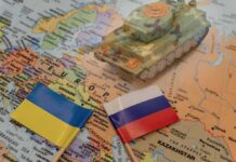 Toy tank on map with Ukraine and Russia flags.