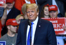 Person at a rally with Make America Great Again signs