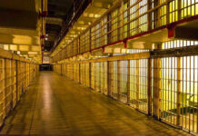 Empty hallway between rows of prison cells
