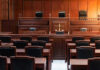 Empty courtroom with wooden benches and judge's bench