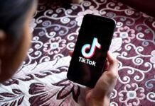 Hand holding phone showing TikTok logo