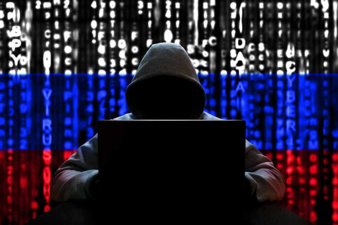 Hacker in hoodie with Russian flag background and code
