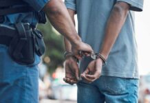 Police officer handcuffing a persons hands behind back