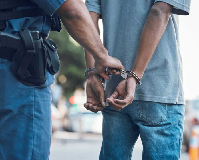 2337392319 featured image Police officer handcuffing a persons hands behind back