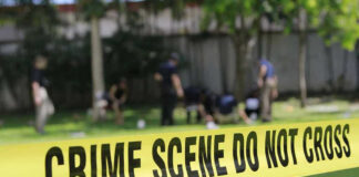 Yellow crime scene tape blocking grassy area