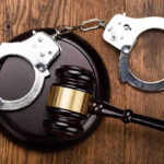 Gavel and handcuffs on wooden surface