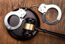 Gavel and handcuffs on wooden surface