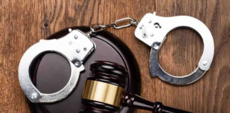 Gavel and handcuffs on wooden surface