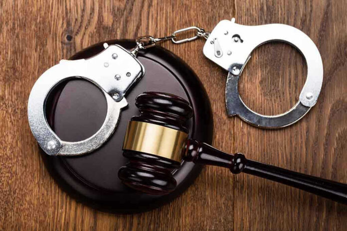 Gavel and handcuffs on wooden surface