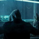 Hacker in hoodie arrested at computer desk