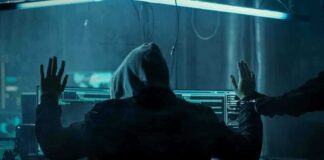 Hacker in hoodie arrested at computer desk