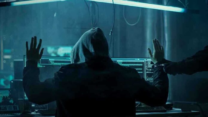 680075263 featured image Hacker in hoodie arrested at computer desk