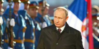 A man in dark coat at a military event