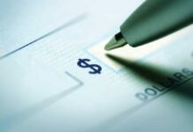 Close up of a pen poised over a check with a dollar sign