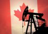 Silhouette of an oil rig against the Canadian flag