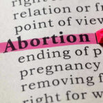 "Abortion" highlighted in a dictionary with a pink marker.