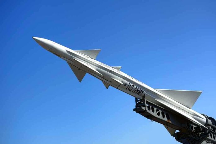 A military missile pointed upwards against a clear blue sky
