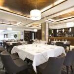 Ice Machine Filth—What Restaurants Won’t Admit Interior of a modern restaurant with elegantly set tables and a bar area