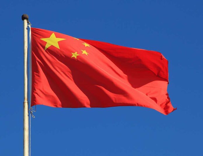 shutterstock_70563685.jpg Chinese national flag waving against a clear blue sky