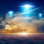 Glowing lights above dramatic sunset clouds.