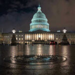 Congressman’s Brawl Ignites Capitol Chaos U.S. Capitol building illuminated at night with wet pavement.