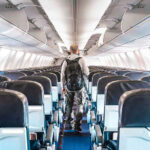 FAA Orders Shocking Carry-On Crackdown Person walking down empty airplane aisle