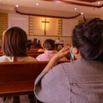 People sitting in church pews during service.