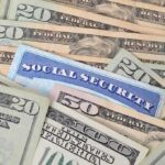 A social security card placed among various denominations of US currency