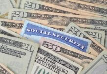 A social security card placed among various denominations of US currency