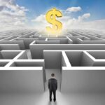 A man in a suit standing at the entrance of a maze with a dollar sign above