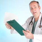 Doctor Celebrates Kirk’s Murder, But NURSE Suspended Without Pay! A doctor in a white coat looking surprised while holding a clipboard
