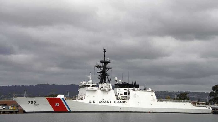 A US Coast Guard ship docked under cloudy skies