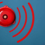 Red alarm bell on a blue background.